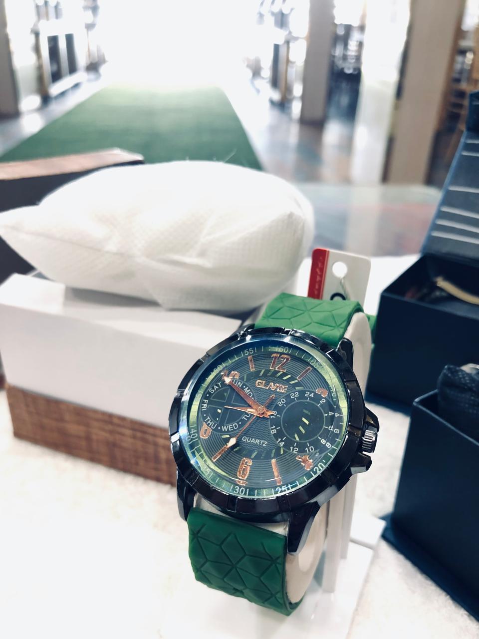 Green watch with a detailed face on a white surface