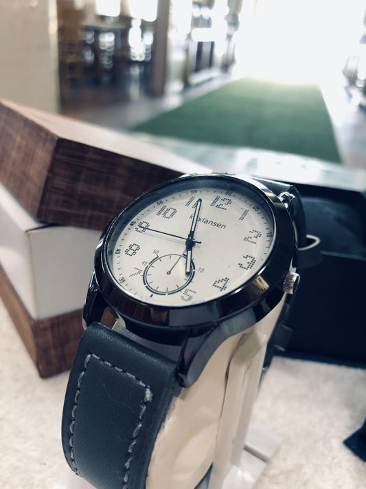Wristwatch with a black leather strap on a blurred indoor background