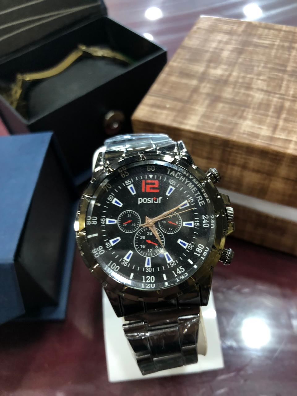 Positif watch with black face and silver case on a reflective surface