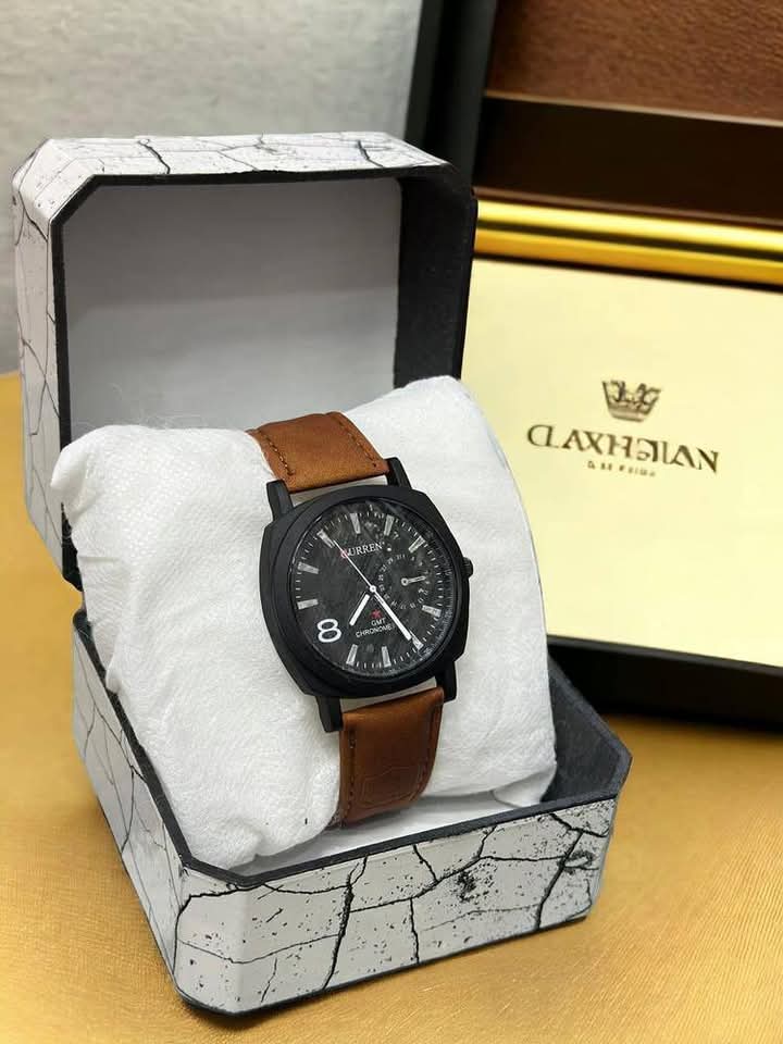 Watch with brown leather strap in a Clavenhagen box on a yellow surface