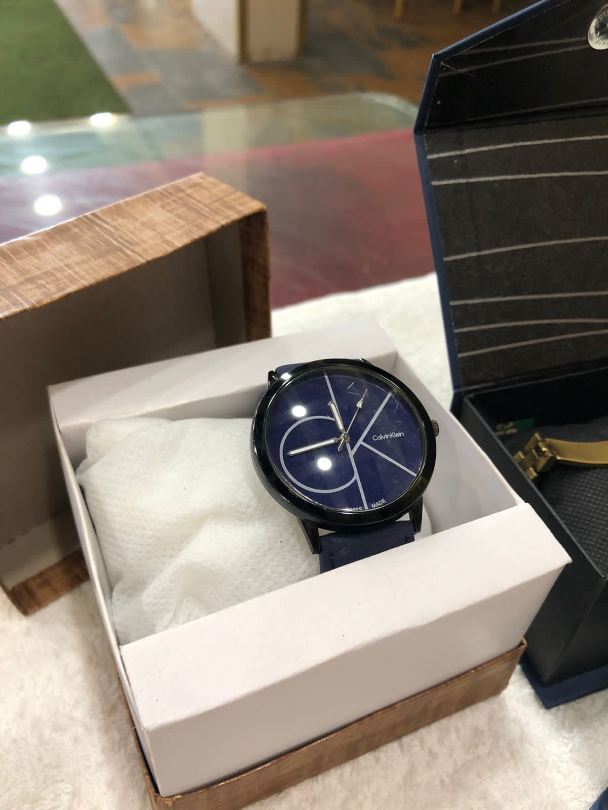 Blue watch in a white box with a wooden base