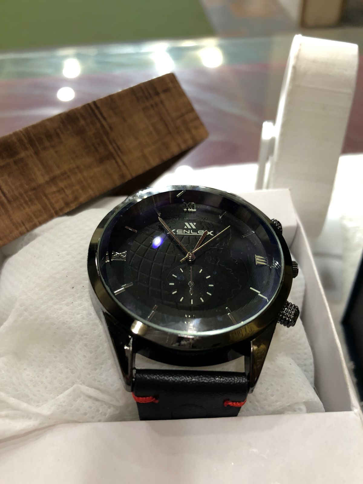 Black wristwatch with a detailed face in a box